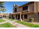 Two-story stucco condo with Spanish tile roof, walkway, and grassy yard at 3491 N Arizona Ave # 54, Chandler, AZ 85225