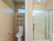 Bathroom with a toilet, shower, and shelving unit at 42521 W Sea Eagle Dr, Maricopa, AZ 85138