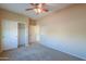 Well-lit bedroom with double door closet and neutral carpeting at 42521 W Sea Eagle Dr, Maricopa, AZ 85138