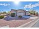 Tan house with a two-car garage and desert landscaping at 42521 W Sea Eagle Dr, Maricopa, AZ 85138