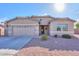 Tan house with a two-car garage and desert landscaping at 42521 W Sea Eagle Dr, Maricopa, AZ 85138