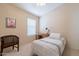 Cozy bedroom with window, and small chair at 43808 W Wade Dr, Maricopa, AZ 85138