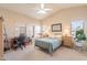 Spacious bedroom with a comfortable bed, built-in workspace, and large windows at 43808 W Wade Dr, Maricopa, AZ 85138