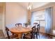 Bright dining room with a wooden table and chairs, and large windows at 43808 W Wade Dr, Maricopa, AZ 85138