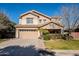 Two-story house with tan exterior, landscaped lawn, and attached garage at 4444 E Peach Tree Dr, Chandler, AZ 85249