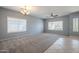 Sunlit living room with large windows, ceiling fan, and carpet flooring at 4444 E Peach Tree Dr, Chandler, AZ 85249