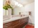 Modern bathroom features wood cabinets, a sleek countertop, and a large mirror for bright reflection at 535 W Thomas Rd # 208, Phoenix, AZ 85013