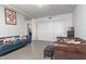 Living room with teal sofa, brown leather chair, and built-in shelving at 535 W Thomas Rd # 208, Phoenix, AZ 85013