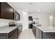 Spacious kitchen featuring dark cabinets, granite counters & island at 5515 E Rock Bush Ln, San Tan Valley, AZ 85140