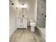 Modern bathroom with white vanity, tile shower, and wood-look floors at 6131 N 36Th Dr, Phoenix, AZ 85019