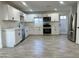 Modern kitchen with white cabinets, stainless steel appliances, and gray flooring at 6131 N 36Th Dr, Phoenix, AZ 85019