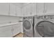 Laundry room with washer, dryer, and ample cabinet space at 8043 E Jaeger St, Mesa, AZ 85207