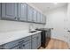 Modern laundry room with gray cabinets and white countertops at 815 E County Down Dr, Chandler, AZ 85249