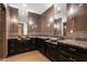 Double vanity bathroom with granite countertop and dark wood cabinets at 8515 E Sutton Dr, Scottsdale, AZ 85260