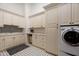 Bright laundry room with white cabinets, washer, dryer, and patterned tile floor at 8515 E Sutton Dr, Scottsdale, AZ 85260