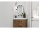 Modern bathroom with a wood vanity and oval mirror at 9031 N 83Rd Way, Scottsdale, AZ 85258