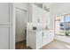 White kitchen cabinets, marble countertops, and a view to the backyard at 9031 N 83Rd Way, Scottsdale, AZ 85258