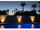 Stunning nighttime pool scene with palm trees and lighting at 9448 N 80Th Pl, Scottsdale, AZ 85258