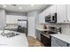 Modern kitchen with gray cabinets, white countertops, and stainless steel appliances at 10022 N Erin Ct, Waddell, AZ 85355