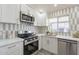 Modern kitchen features white cabinets, stainless steel appliances, and a stylish backsplash at 10811 E Contessa St, Mesa, AZ 85207