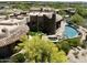 Majestic aerial shot of circular home design featuring beautiful stone, clay tile roof and backyard pool area at 11105 E Tamarisk Way, Scottsdale, AZ 85262