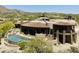 Stunning aerial view of home with private pool, stone accents, and desert landscaping in a picturesque community at 11105 E Tamarisk Way, Scottsdale, AZ 85262
