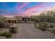 Beautiful home exterior at sunset with a large driveway at 11105 E Tamarisk Way, Scottsdale, AZ 85262