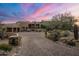 Stunning home exterior at sunset with a large driveway at 11105 E Tamarisk Way, Scottsdale, AZ 85262