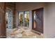 Inviting entryway with a unique wood door and stone accents at 11105 E Tamarisk Way, Scottsdale, AZ 85262