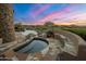 Hot tub with stone surround, nestled in a desert landscape with mountain views at 11105 E Tamarisk Way, Scottsdale, AZ 85262