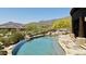 Inviting pool area showing stone edging and tranquil desert views, nestled next to covered part of home at 11105 E Tamarisk Way, Scottsdale, AZ 85262
