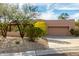 Tan stucco house with a two-car garage and mature desert landscaping at 11686 N Spotted Horse Way, Fountain Hills, AZ 85268