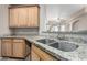 Kitchen features double sinks, granite countertops, and wood cabinets at 14575 W Mountain View Blvd # 12303, Surprise, AZ 85374