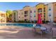 Community pool with patio furniture and red umbrella at 14575 W Mountain View Blvd # 12303, Surprise, AZ 85374