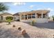 Landscaped backyard with gravel and a covered patio at 15820 W Falcon Ridge Dr, Sun City West, AZ 85375