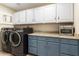 Bright laundry room with washer, dryer, granite countertops, and ample cabinetry at 15820 W Falcon Ridge Dr, Sun City West, AZ 85375