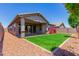 Landscaped backyard with grassy area and covered patio at 16019 W Avenida Del Sol --, Surprise, AZ 85387