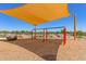 Play area with swings and shade structure at 16019 W Avenida Del Sol --, Surprise, AZ 85387