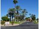 Gated entrance to Happy Trails Resort, palm trees, and guardhouse at 17200 W Bell Rd # 387, Surprise, AZ 85374