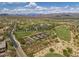 Expansive aerial view showcases the community's tennis courts, golf course, and desert landscape with mountain views at 17527 E Silver Sage Ln, Rio Verde, AZ 85263