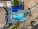 Top-down view of a resort-style pool with blue umbrellas, ample seating, and tropical landscaping at 19462 N Star Ridge Dr, Sun City West, AZ 85375