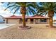 Landscaped front yard featuring palm trees and gravel at 19606 N Trail Ridge Dr, Sun City West, AZ 85375