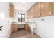 Bright laundry room with built-in cabinets and a utility sink at 19606 N Trail Ridge Dr, Sun City West, AZ 85375