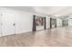 Living room with white walls, wood-look floors, and a mirrored wall at 19606 N Trail Ridge Dr, Sun City West, AZ 85375