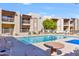 Community pool with surrounding patio furniture and trees at 205 N 74Th St # 122, Mesa, AZ 85207