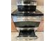 Close-up of a modern stainless steel oven with glass cooktop and granite countertops at 21280 N 262Nd Dr, Buckeye, AZ 85396