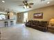 Spacious living room featuring tile flooring, ceiling fan, and a view into the kitchen at 21280 N 262Nd Dr, Buckeye, AZ 85396