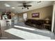 Spacious living room featuring tile flooring, ceiling fan, and comfortable leather sofa at 21280 N 262Nd Dr, Buckeye, AZ 85396