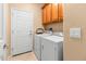 Bright laundry room with washer, dryer, and built-in cabinets at 21280 N 262Nd Dr, Buckeye, AZ 85396