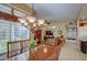 Open dining area with a large table and chandelier, overlooking the living room at 21413 N 159Th Dr, Sun City West, AZ 85375